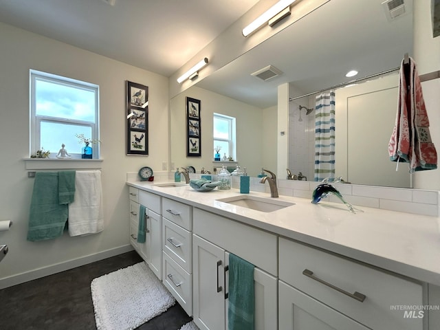 full bathroom with visible vents, baseboards, and a sink