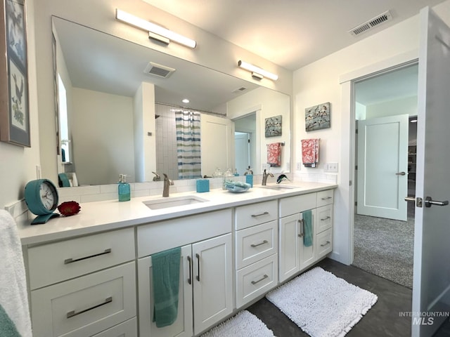 bathroom featuring double vanity, visible vents, and a sink