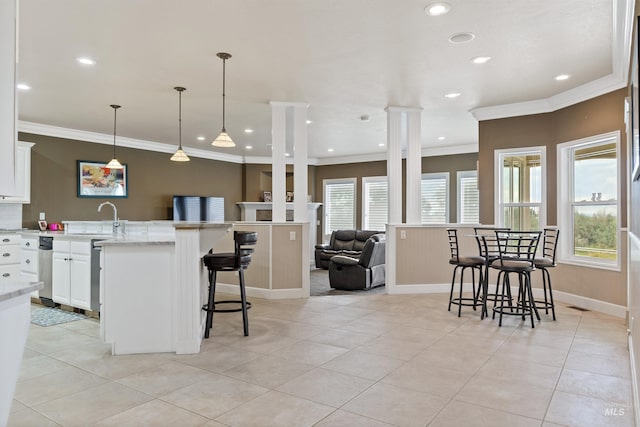 kitchen with white cabinets, a breakfast bar area, and plenty of natural light