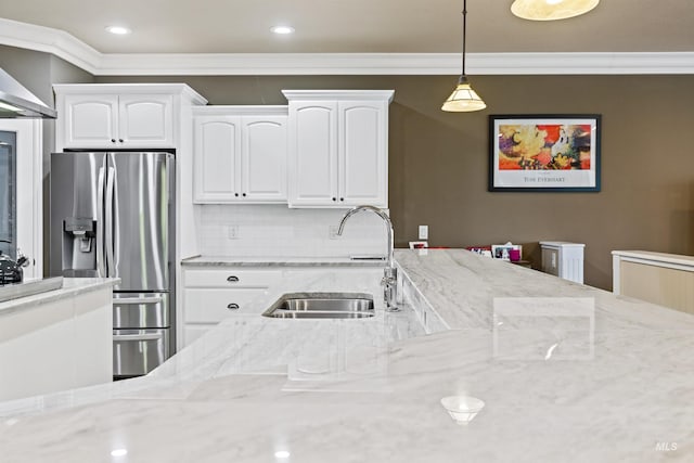 kitchen featuring sink, stainless steel refrigerator with ice dispenser, white cabinetry, hanging light fixtures, and light stone countertops