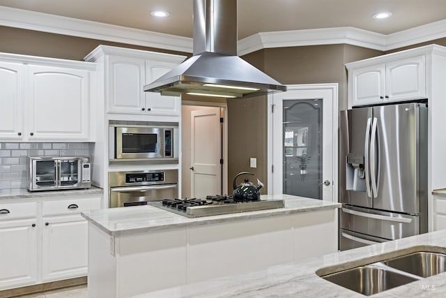 kitchen with light stone countertops, island exhaust hood, appliances with stainless steel finishes, and white cabinets