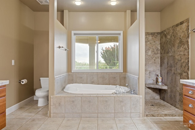 bathroom featuring a relaxing tiled tub, vanity, toilet, and tile patterned floors