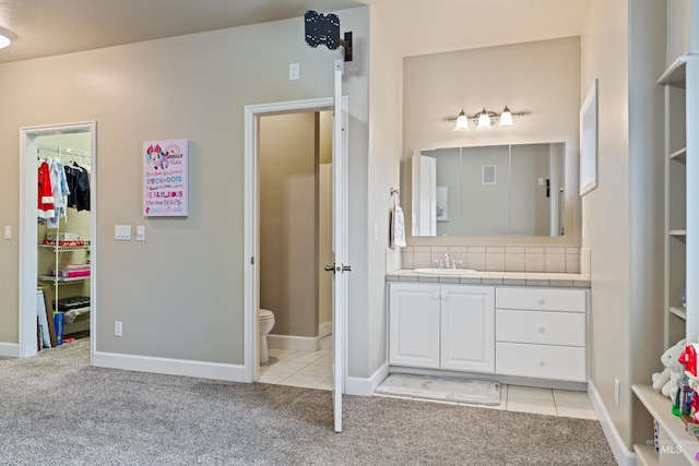 bathroom with backsplash, vanity, tile patterned flooring, and toilet