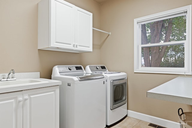 laundry room featuring cabinets, light tile patterned flooring, separate washer and dryer, and sink