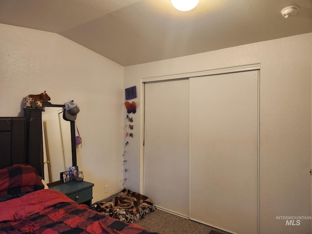 unfurnished bedroom with carpet flooring, a closet, and vaulted ceiling