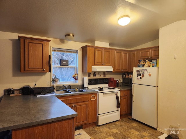 kitchen with a textured ceiling, white appliances, sink, and vaulted ceiling