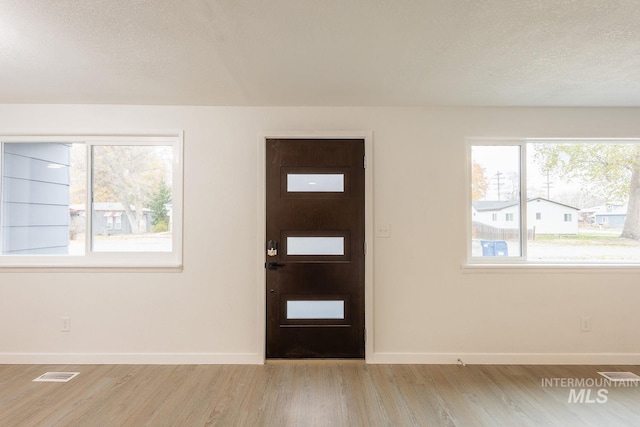 entryway featuring a textured ceiling and light wood-type flooring