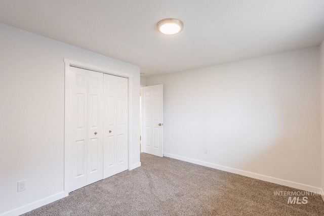 unfurnished bedroom with carpet flooring and a closet