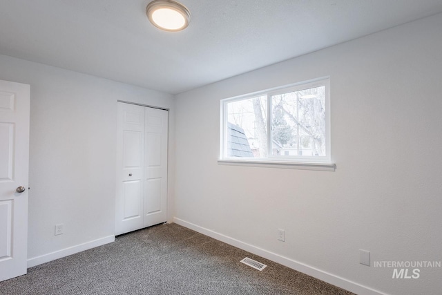 unfurnished bedroom with carpet flooring and a closet