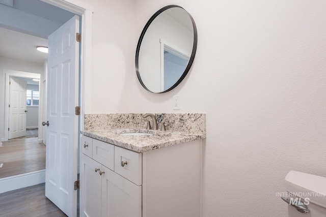 bathroom with vanity, hardwood / wood-style floors, and toilet