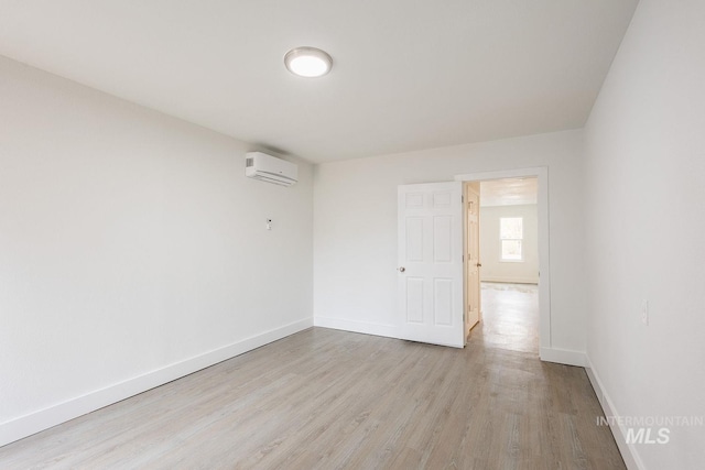 empty room featuring light hardwood / wood-style floors and a wall unit AC