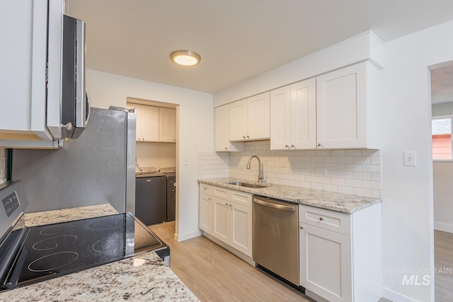 kitchen with white cabinetry, sink, stainless steel dishwasher, range, and washer and clothes dryer