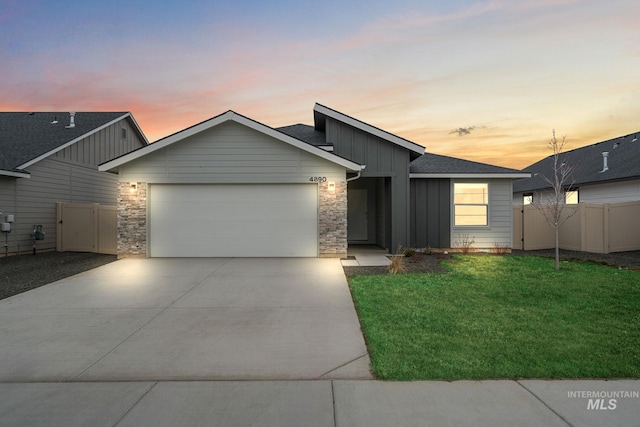 view of front of property with a garage, board and batten siding, concrete driveway, and fence