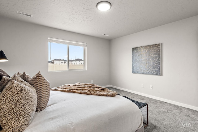 carpeted bedroom featuring visible vents, baseboards, and a textured ceiling