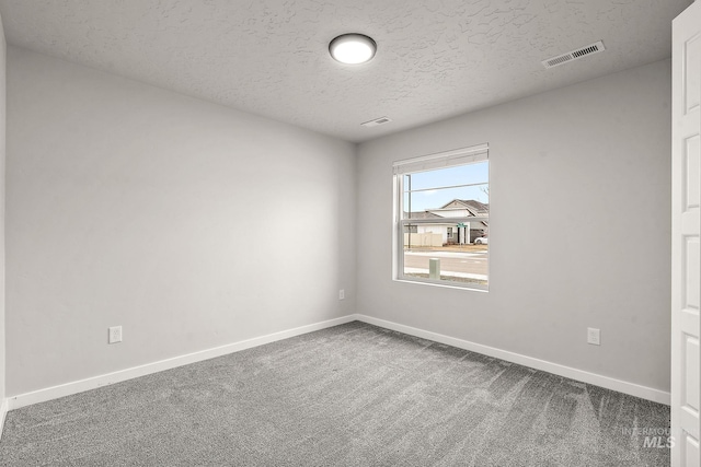 unfurnished room featuring visible vents, carpet floors, a textured ceiling, and baseboards