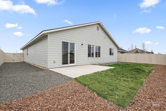 back of house with a gate, a patio area, a yard, and a fenced backyard