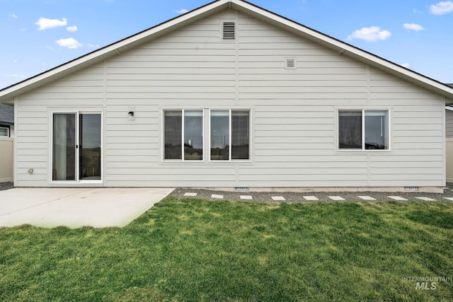 back of house with crawl space, a patio, and a yard