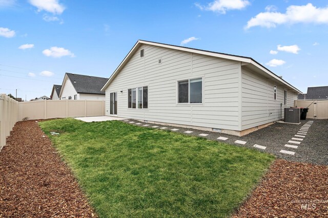 rear view of property with a patio, a lawn, central AC, and a fenced backyard