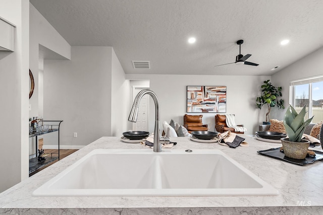 room details featuring visible vents, recessed lighting, a textured ceiling, a ceiling fan, and a sink