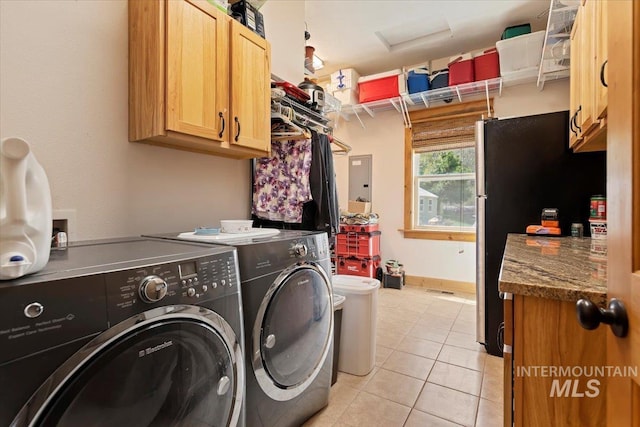 laundry room with electric panel, cabinets, light tile patterned floors, and washer and clothes dryer