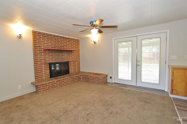 unfurnished living room featuring french doors, a fireplace, visible vents, carpet flooring, and ceiling fan