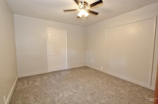 spare room featuring ceiling fan, baseboards, and light colored carpet