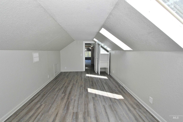 bonus room featuring lofted ceiling, visible vents, dark wood-type flooring, a textured ceiling, and baseboards