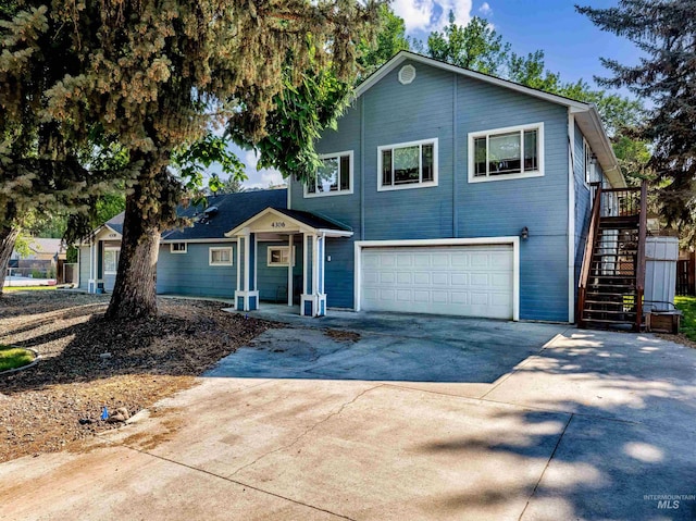 traditional-style house with stairs, concrete driveway, and a garage