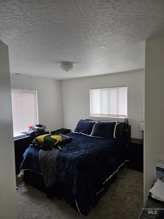 carpeted bedroom featuring a textured ceiling