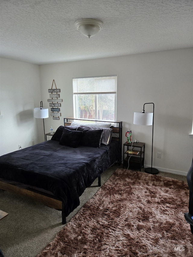 bedroom with a textured ceiling, carpet flooring, and baseboards