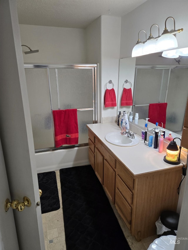 full bath with enclosed tub / shower combo, vanity, and tile patterned floors