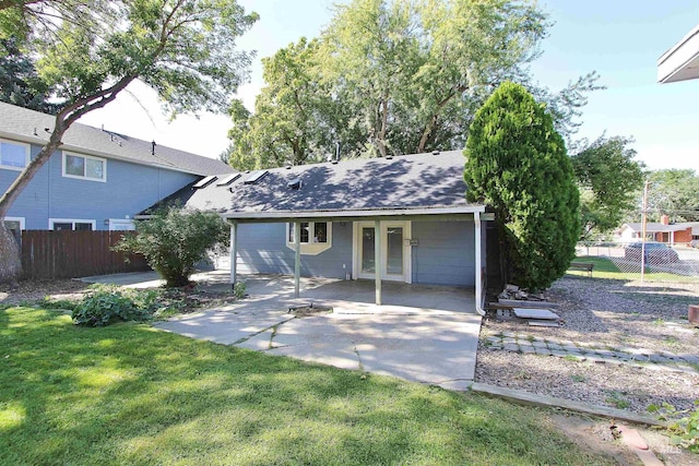 view of front of property featuring french doors, a patio area, fence, and a front lawn