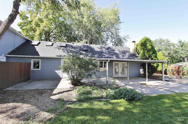 rear view of house featuring french doors, a chimney, a patio area, and fence