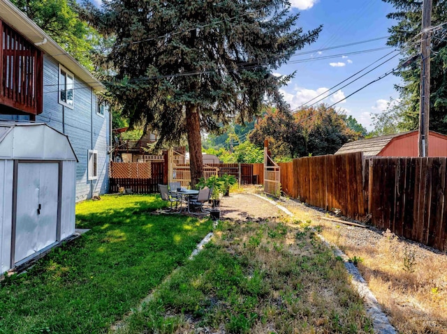 view of yard with an outbuilding, a fenced backyard, and a shed