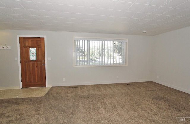 carpeted foyer featuring baseboards