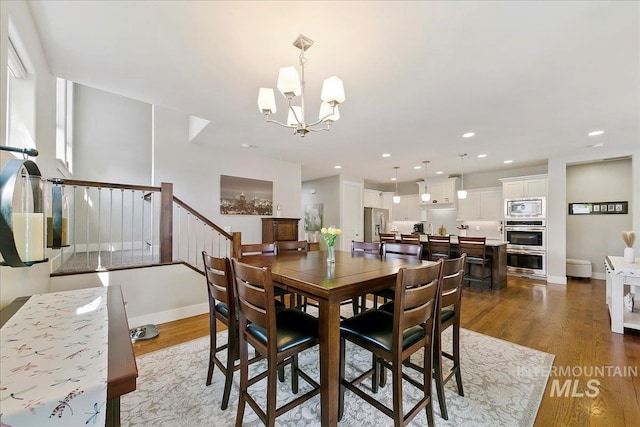 5726 N Morpheus Way, Meridian, ID 83642 - dining space with wood finished floors, a chandelier, baseboards, and recessed lighting