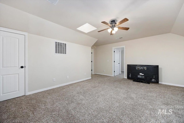 additional living space featuring lofted ceiling with skylight, carpet, and ceiling fan