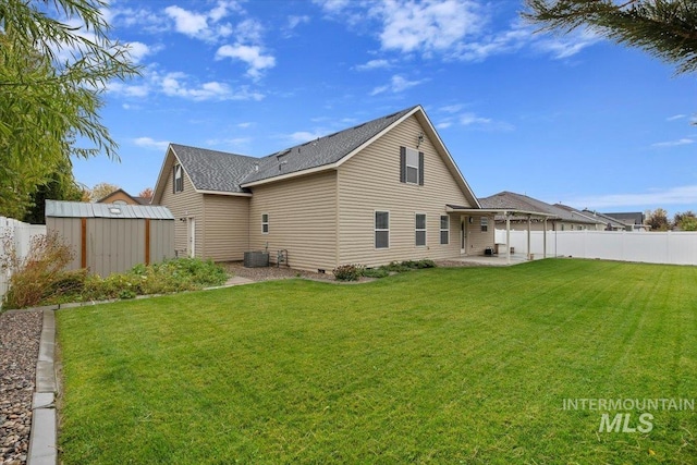 rear view of house featuring a shed, a yard, and a patio