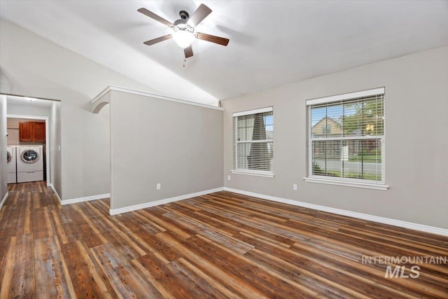 empty room with vaulted ceiling, washer and clothes dryer, dark hardwood / wood-style floors, and ceiling fan