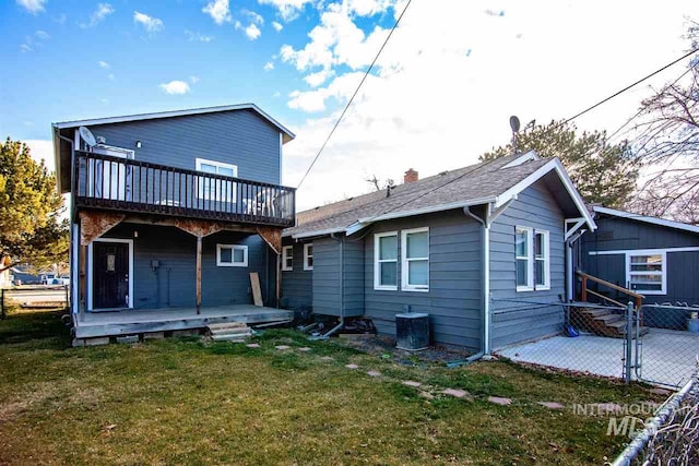 back of house with a lawn and a deck