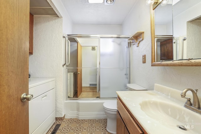 2144 Crestwood Dr, Twin Falls, ID 83301 - bathroom with toilet, vanity, a textured wall, washer / clothes dryer, and combined bath / shower with glass door