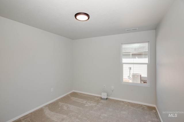 5814 W Mikonos St, Meridian, ID 83646 - empty room with visible vents, baseboards, light colored carpet, and a textured ceiling