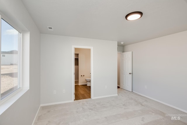5814 W Mikonos St, Meridian, ID 83646 - unfurnished bedroom featuring visible vents, baseboards, ensuite bathroom, and carpet