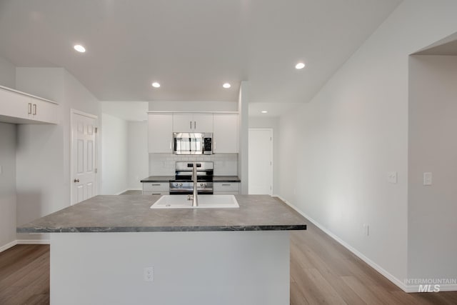 5814 W Mikonos St, Meridian, ID 83646 - kitchen with white cabinets, dark countertops, tasteful backsplash, and appliances with stainless steel finishes