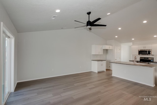 5814 W Mikonos St, Meridian, ID 83646 - unfurnished living room featuring ceiling fan, baseboards, light wood-style flooring, and lofted ceiling