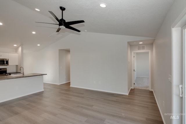 5814 W Mikonos St, Meridian, ID 83646 - unfurnished living room with visible vents, ceiling fan, light wood-type flooring, and vaulted ceiling