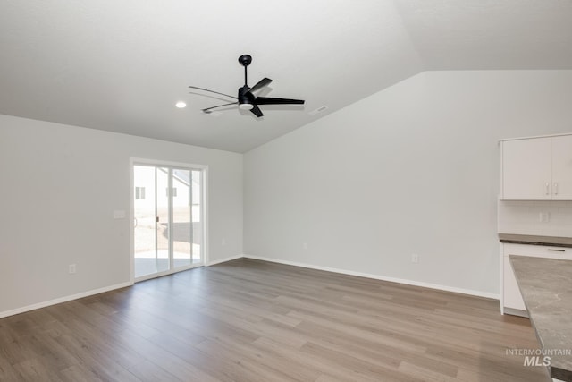 5814 W Mikonos St, Meridian, ID 83646 - unfurnished room with baseboards, light wood-style floors, vaulted ceiling, and a ceiling fan