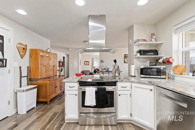 kitchen featuring light stone countertops, hardwood / wood-style flooring, stainless steel appliances, island exhaust hood, and white cabinets