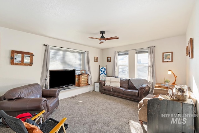 living room with ceiling fan and carpet