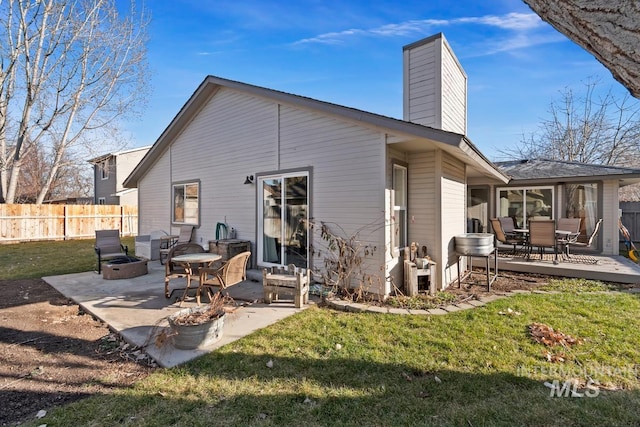 back of house with an outdoor fire pit, a patio area, and a lawn